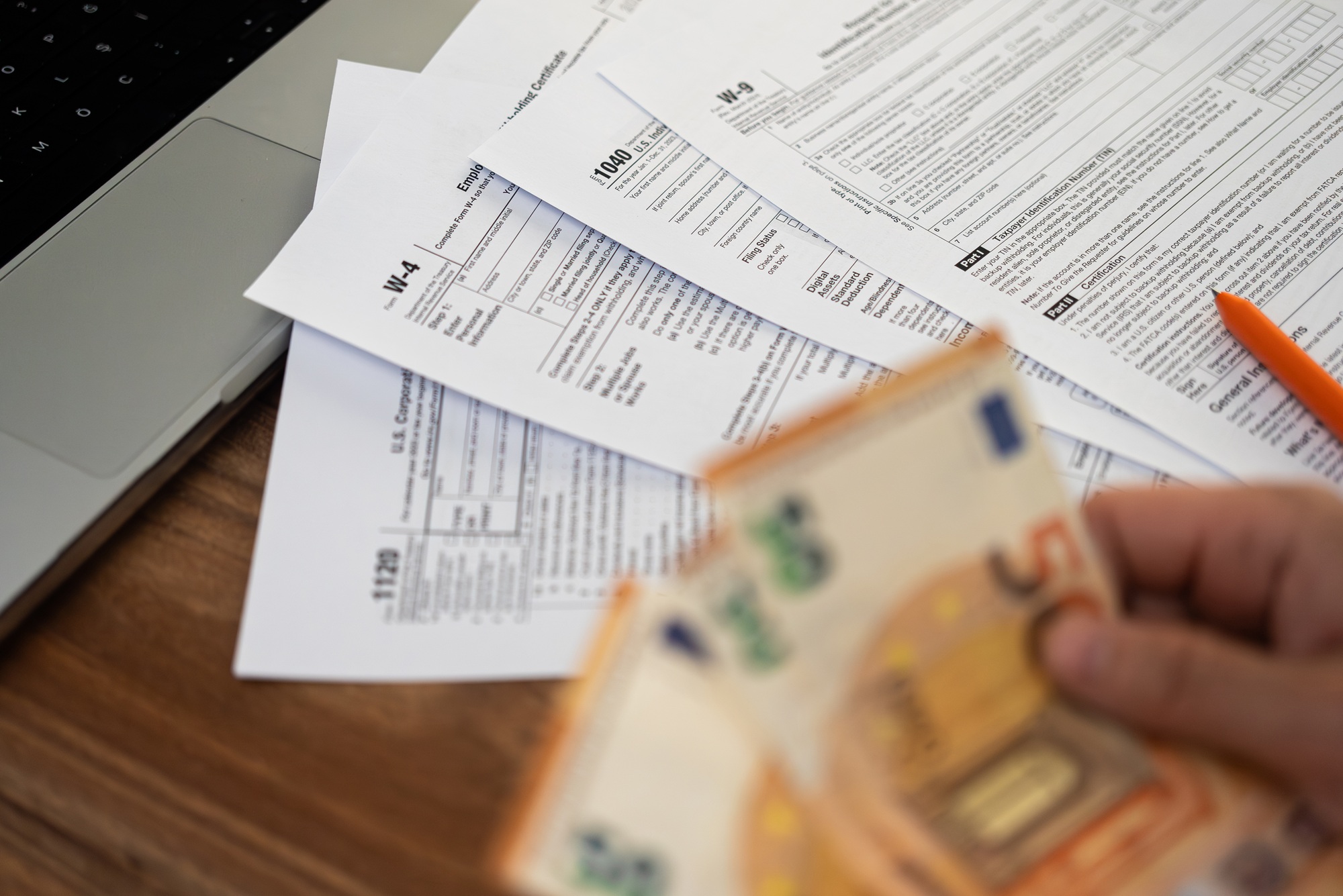 Accountant hand holds euro banknotes preparing financial information for filling various tax forms