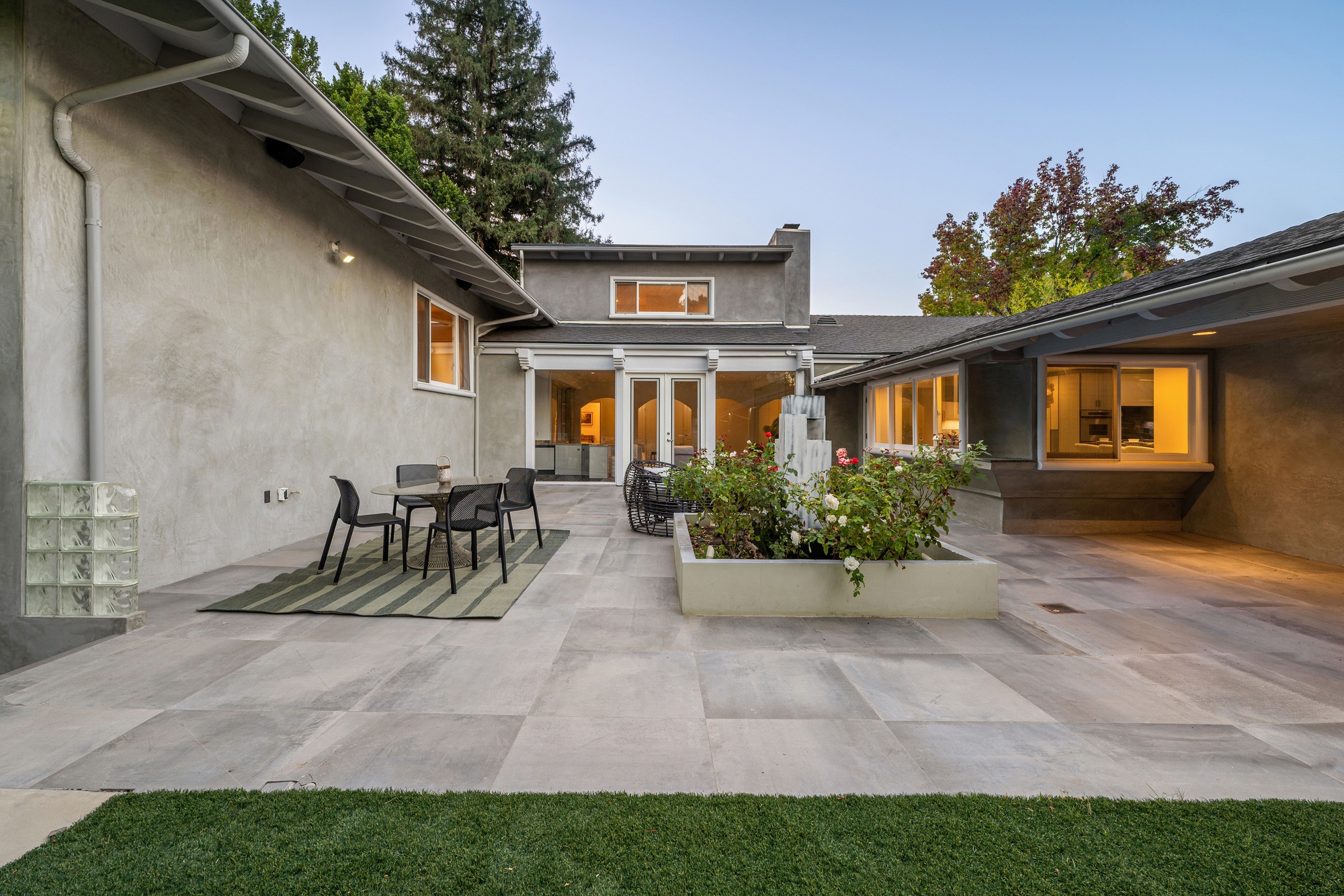 Modern patio with garden and house exterior at dusk.